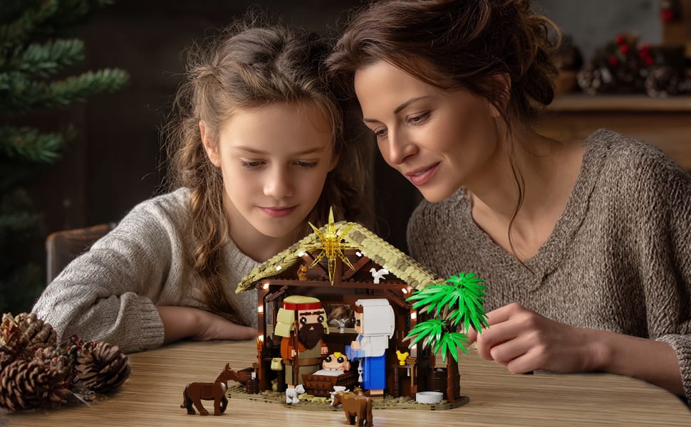 Mor og datter ser på den ferdige julekrybba med lyset på